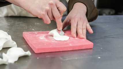 pasticcere prepara fiori di zucchero per una torta nuziale