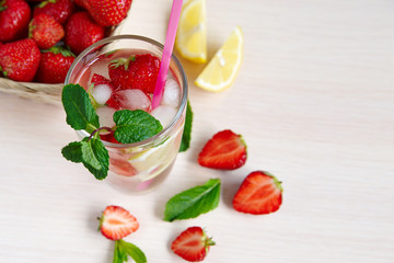 Still life of strawberries, lemon, cold drink with mint