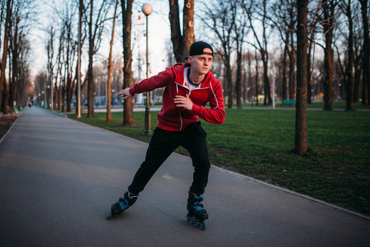 Roller skater rides by sidewalk in city park