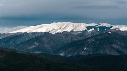 Fototapeta na wymiar Snowy road and mountains in winter