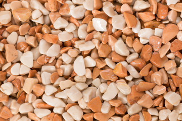 Small orange and white wet pebble stone floor background texture.