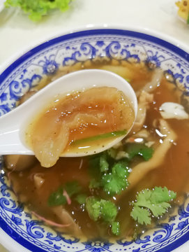 Braised Sea Cucumber in Brown Soup in in white spoon and beautiful blow