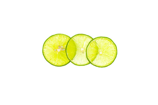 Green lemon sliced and stacked isolated on white background.
