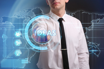 Business, Technology, Internet and network concept. Young businessman working on a virtual screen of the future and sees the inscription: Ideas