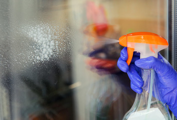 Woman cleaning a window with cleaning sprayer