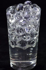 Silicone balls in a glass with water on a black background