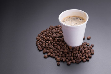 Hot americano coffee in paper cup of coffee and coffee beans on black background