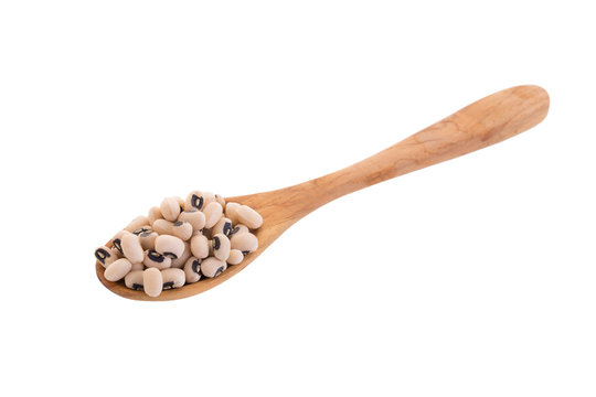 Black-eyed peas in a wooden spoon isolated on a white background
