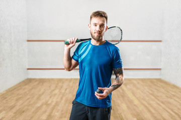 Squash game player with racket and ball in hands
