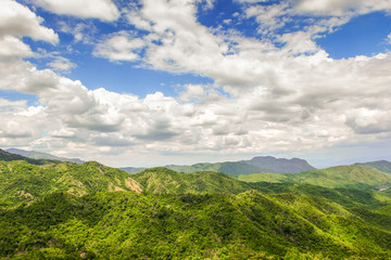 Beautiful mountain landscape, with mountain peaks covered with forest and a cloudy sky