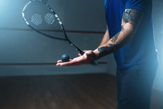 Male squash player training on indoor court