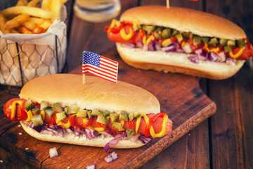 American hot dog with pickles,onions, ketchup, mustard and french fries at a Picnic for 4th of July 