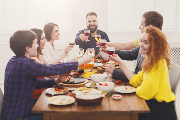 People say cheers clink glasses at festive table dinner party