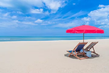 Store enrouleur Plage et mer Beach chair with red umbrella on tropical beach in blue sky.