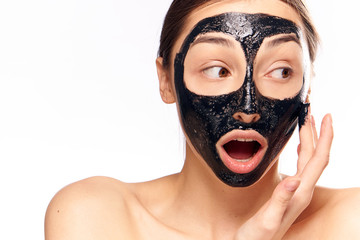 surprised woman with black mask on face, light background