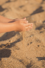 child hands closeup. from hand pours sand lifestyle contact pedigree ancestry