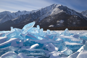 Blue ice hummocks on snowy mountains background