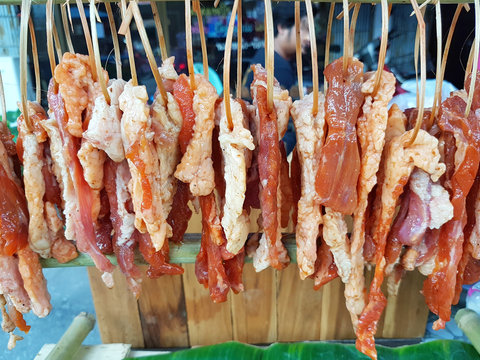 raw or uncooked beef on bamboo strips sold in street market in Thailand