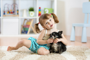 Lovely little girl playing with her pet dog