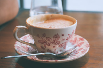 A cup of latte / caffe latte in vintage style. A latte is a coffee drink made with espresso and steamed milk.