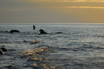 Silhouette eines Anglers  im  Sonnenuntergang 