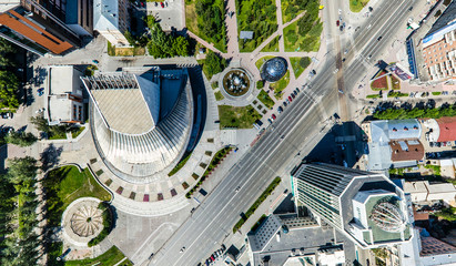 Aerial city view with crossroads, roads, houses, buildings, parks and parking lots. Copter drone helicopter shot. Panoramic wide angle image.