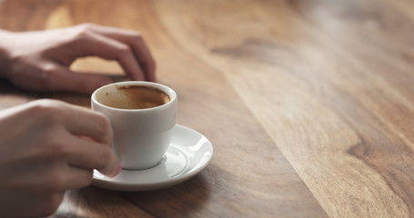 Young man hand with coffee cup waiting tapping fingers sitting at the table