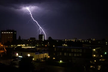 Fototapeten Lightning above city at night. © GojeroPhoto