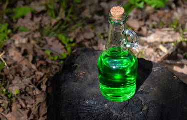 Green herbal potion On the burnt stump. Herbal elixir. Magic Potion. Homeopathic medicine.