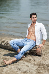 Fototapeta na wymiar young sexy man on a beach,shallow depth of field
