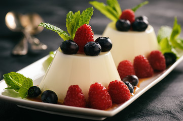 Italian dessert - panna cotta with berries and caramel sauce.