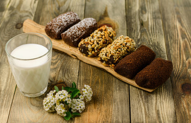 Truffle cakes (potato cake) and a glass of milk on a wooden cutting board.