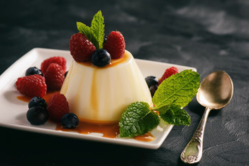 Italian dessert - panna cotta with berries and caramel sauce.