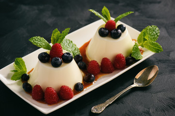 Italian dessert - panna cotta with berries and caramel sauce.