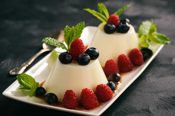 Italian dessert - panna cotta with berries and caramel sauce.