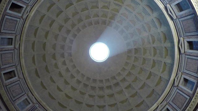 Rome Italy Pantheon famous tourist attraction turning around looking upwards to roof bright light beam from outside sky from oculus and the inside of concrete dome around it largest dome in world 4k