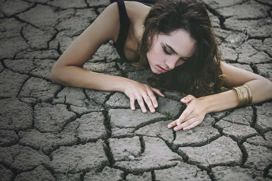 Beautiful young girl on the cracked earth in  dress