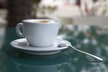 Утренний капучино в белой чашке.