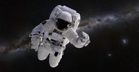 Obraz na płótnie Canvas Astronaut in front of the Milky Way galaxy