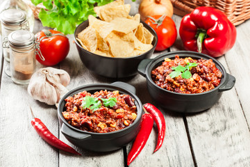 Bowls of hot chili con carne with ground beef, beans, tomatoes and corn