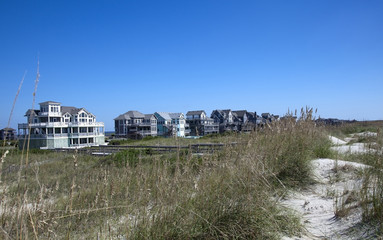 Fototapeta na wymiar North Carolina summer beach rentals with sand dunes and blue sky.
