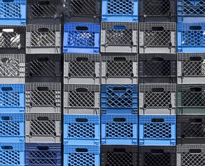 Stacked black and blue plastic container crates.