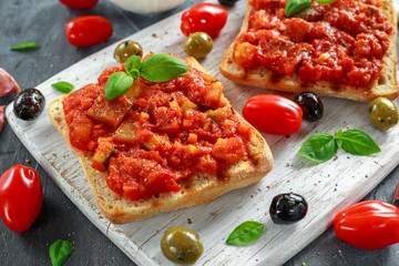 Fresh homemade crispy Italian appetizer Bruschetta topped with tomato, eggplant, Zucchini, Yellow pepper, garlic and basil on white wooden board. healthy food