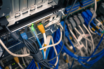 Close up of network internet cables, patch cords connected to black switch router in data center...