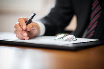 Businessman writing in a documen