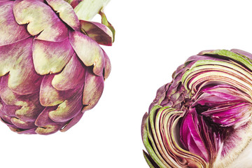 Purple artichokes, one of them cut in half, on a white background. Top view