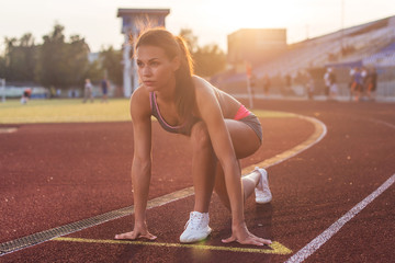 Fit woman in starting position ready for running.