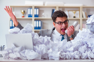 Businessman in paper recycling concept in office