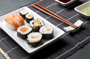 Japońskie sushi w rolkach na czarnej bambusowej macie