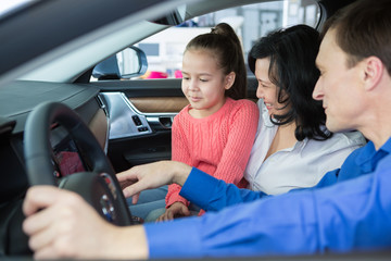 Happy international family buying a car at the dealership